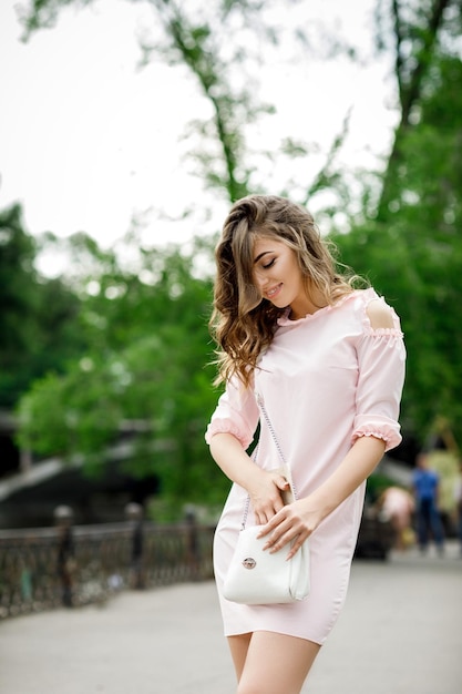 Bella ragazza con la borsetta nel parco