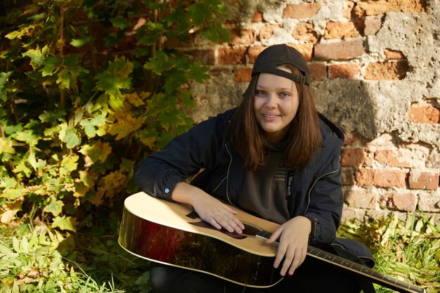 Bella ragazza con la chitarra all'aperto