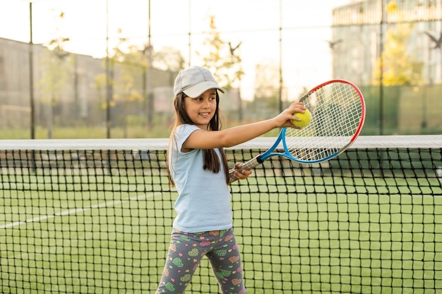 Bella ragazza con la racchetta in mano a giocare a tennis