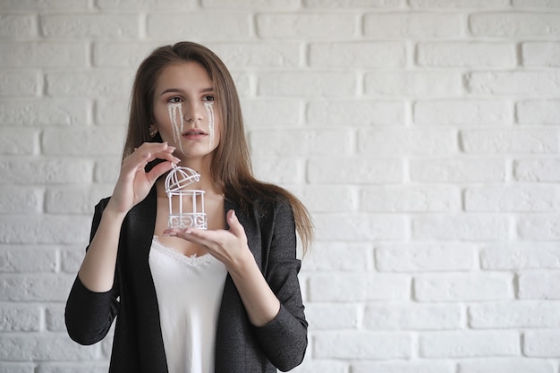 Bella ragazza con le lacrime agli occhi. Ragazza giovane con lacrime dipinte in posa sulla macchina fotografica. Ragazza per carnevale con maschera e trucco.