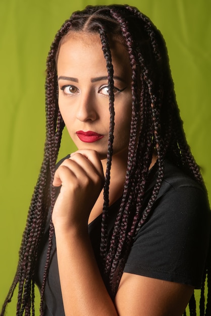 Bella ragazza con le trecce tra i capelli, sfondo colorato, fuoco selettivo.