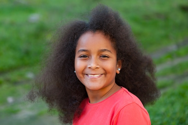 Bella ragazza con lunghi capelli afro in giardino