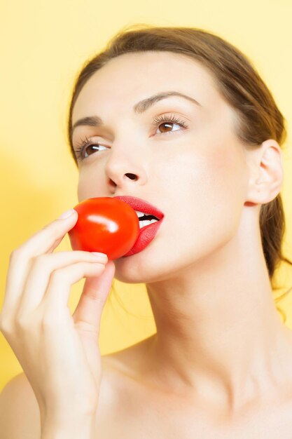 Bella ragazza con pomodoro rosso