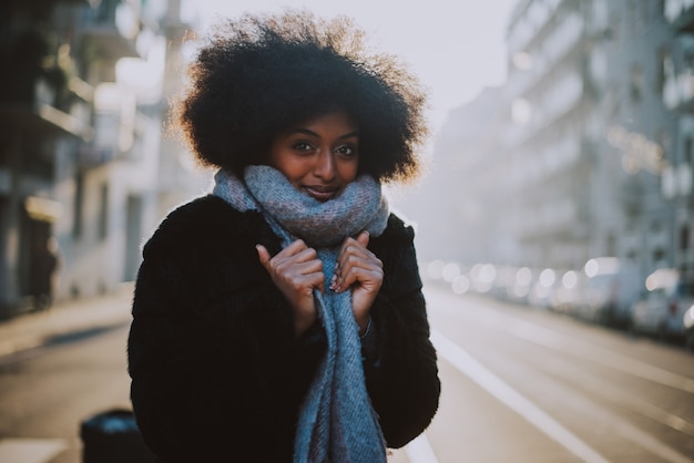 Bella ragazza con taglio di capelli afro che cammina sulla strada