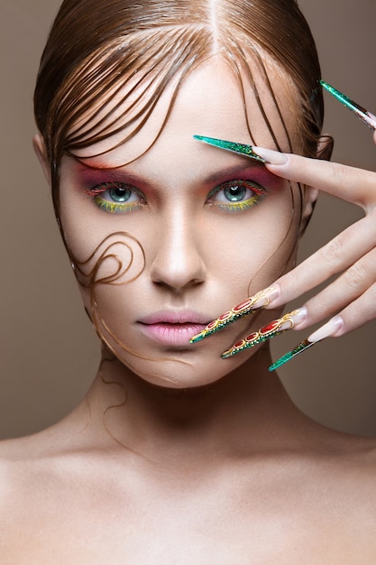 Bella ragazza con trucco luminoso alla moda, acconciatura creativa, unghie lunghe.