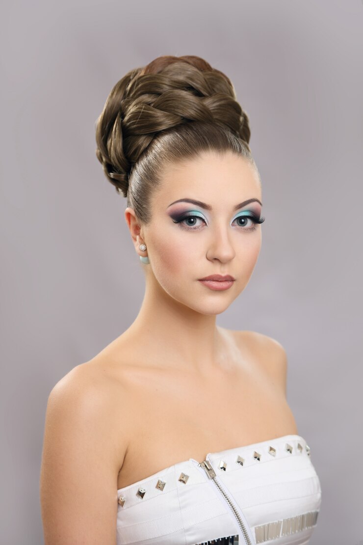 Bella ragazza con trucco luminoso e capelli alti.
