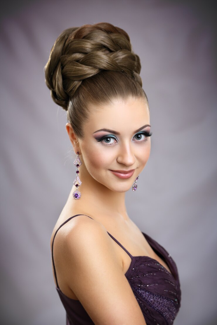 Bella ragazza con trucco luminoso e capelli alti.