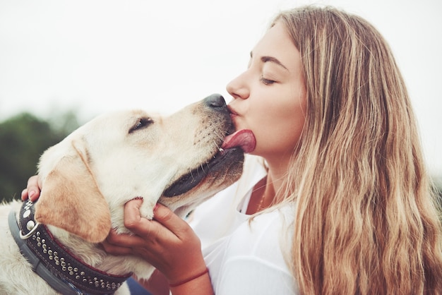 bella ragazza con un bel cane in un parco sull'erba verde.