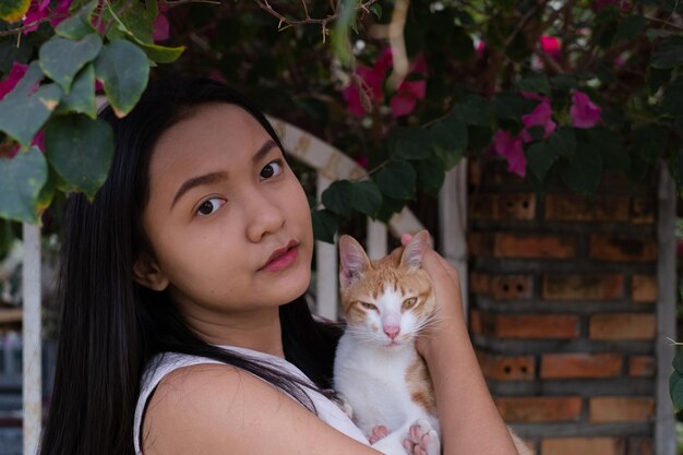 Bella ragazza con un gatto fuori dalla porta