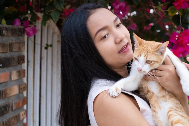 Bella ragazza con un gatto fuori dalla porta