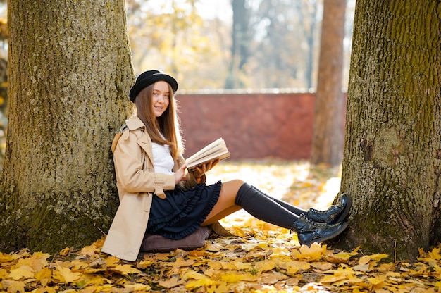 Bella ragazza con un libro nella foresta