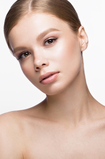 Bella ragazza con un trucco naturale leggero. Viso di bellezza. Foto scattata in studio su sfondo bianco.