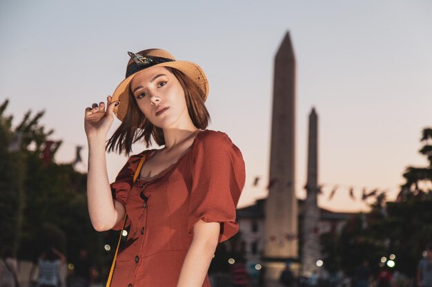 Bella ragazza con vestito di colore arancione che posa alla vecchia piazza dell'Ippodromo da bizantina e da Roma