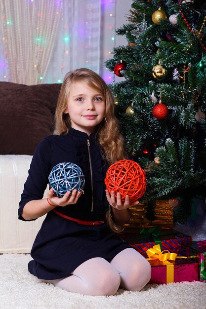 Bella ragazza dai capelli bianchi caucasica in posa vicino al camino Natale e l'umore del nuovo anno