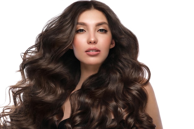 Bella ragazza dai capelli castani con capelli perfettamente arricciati e trucco classico Bellezza viso e capelli