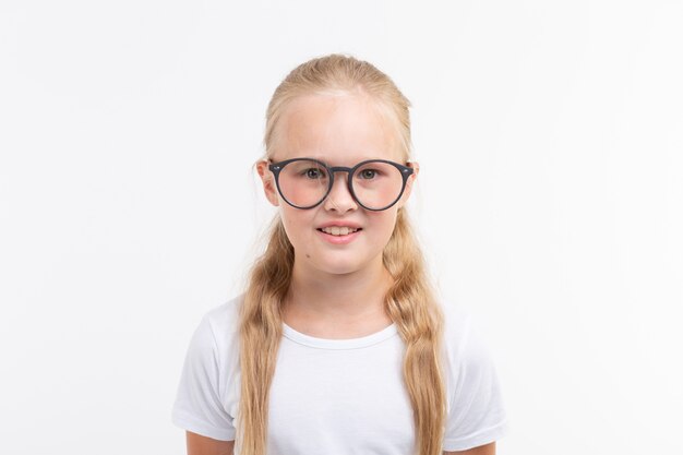 Bella ragazza del bambino con gli occhiali isolati su bianco.