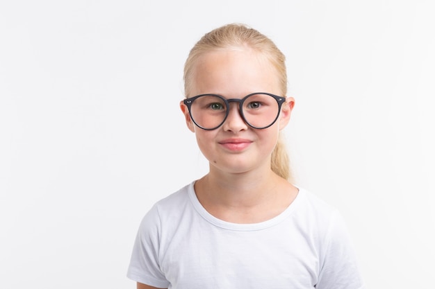 Bella ragazza del bambino con gli occhiali isolati su bianco.