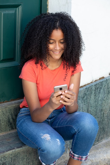 Bella ragazza dell'adolescente con un cellulare