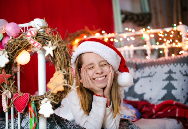 Bella ragazza di circa dieci anni, posa per un fotografo in un interno natalizio
