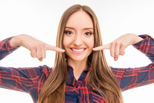 Bella ragazza dolce sorridente e puntare il dito contro i denti bianchi