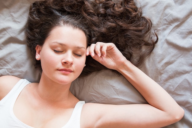 Bella ragazza dorme nel letto