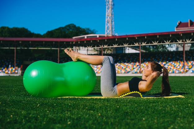 Bella ragazza facendo esercizi con fitball