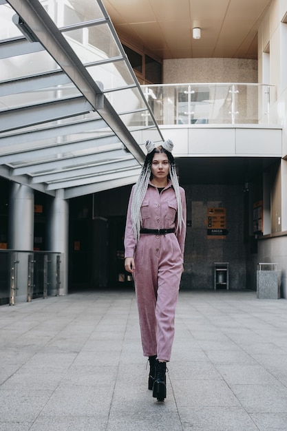 Bella ragazza fresca con i dreadlocks foto a figura intera nello stile urbano della città