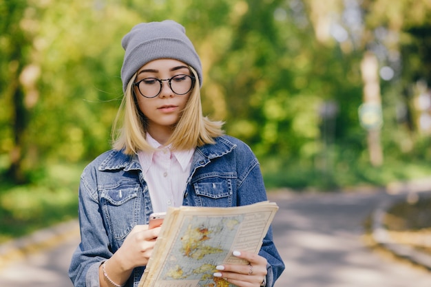 bella ragazza giovane ed elegante che cammina per il parco e cerca una direzione