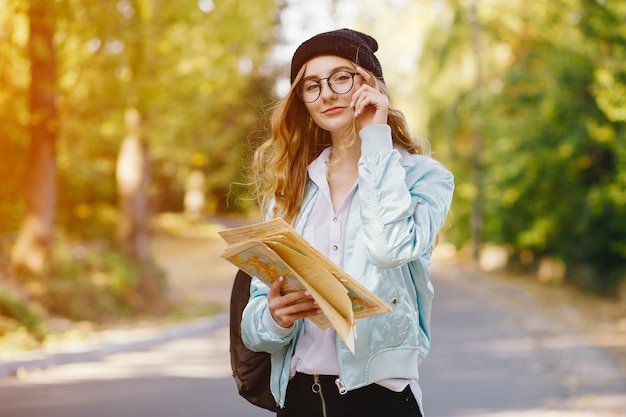 bella ragazza giovane ed elegante che cammina per il parco e cerca una direzione