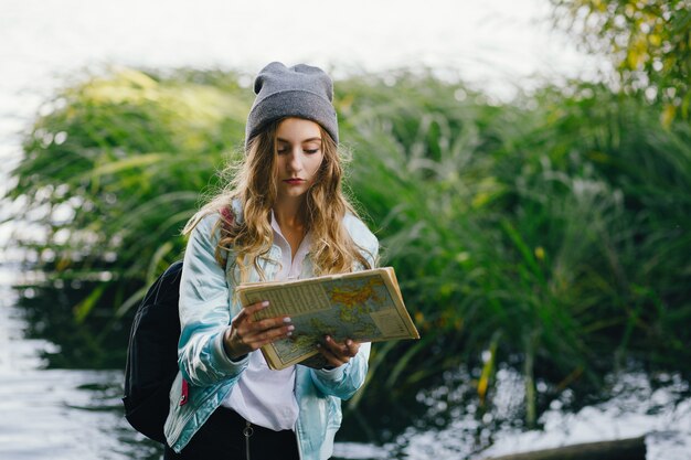 bella ragazza giovane ed elegante che cammina per il parco e cerca una direzione