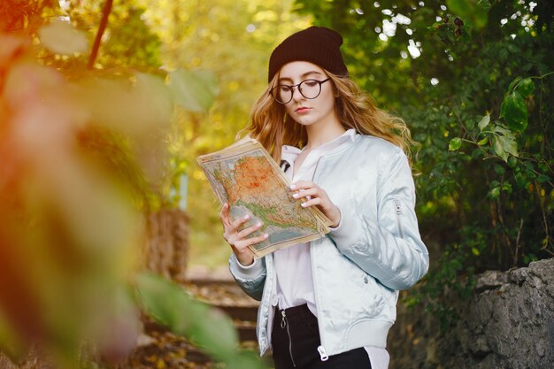 bella ragazza giovane ed elegante che cammina per il parco e cerca una direzione