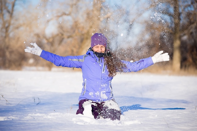 Bella ragazza gode di una passeggiata nel parco in inverno.