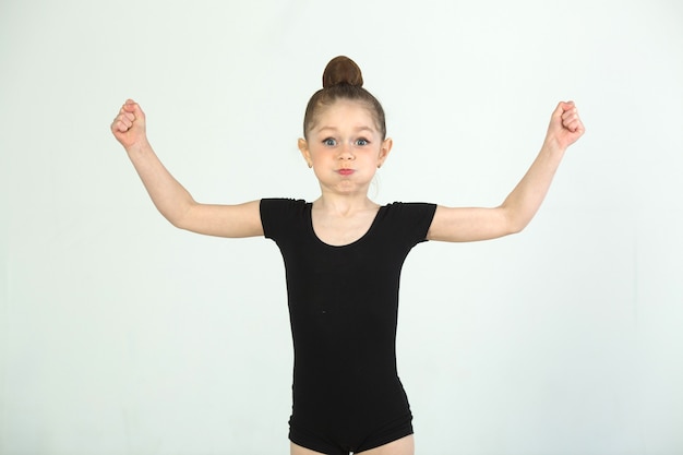 bella ragazza impegnata nella ginnastica su un muro bianco