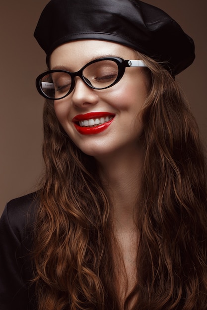 Bella ragazza in abiti eleganti con occhiali per la visione e labbra sexy rosse. Volto di bellezza. Foto scattata in studio