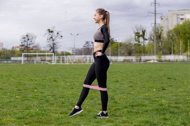 Bella ragazza in abiti sportivi che si esercita all'aperto