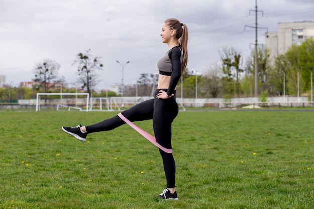 Bella ragazza in abiti sportivi che si esercita all'aperto