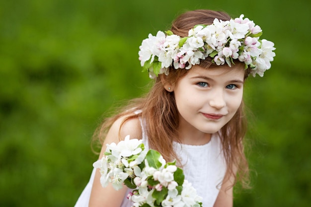 Bella ragazza in abito bianco in giardino con alberi di mele in fiore Ragazza sorridente divertendosi e godendo