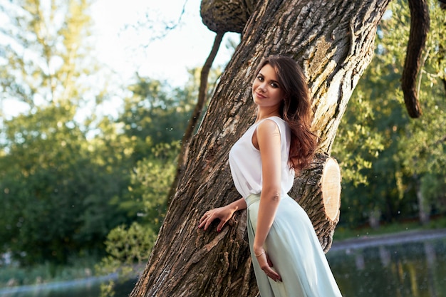 Bella ragazza in abito elegante e affascinante sorriso in posa per il fotografo