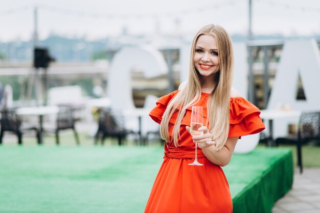 Bella ragazza in abito rosso alla celebrazione