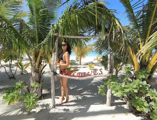 bella ragazza in bikini con palme alle Maldive