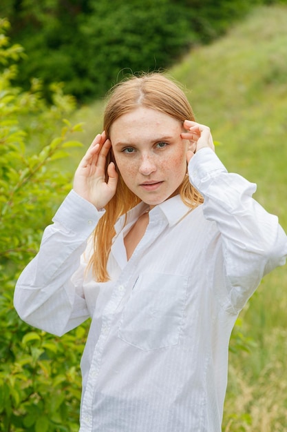 Bella ragazza in camicia bianca e gonna arancione contro il cielo blu e le nuvole