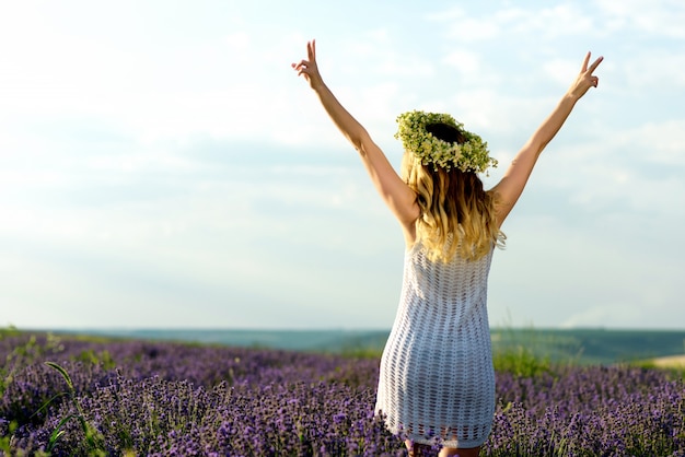 Bella ragazza in campo di lavanda. Pretty woman in stile provenzale in abito bianco e corona di fiori