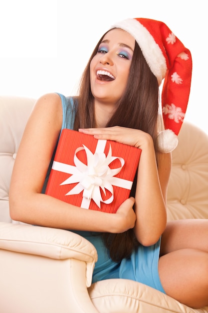Bella ragazza in cappello di Natale con regalo in mano