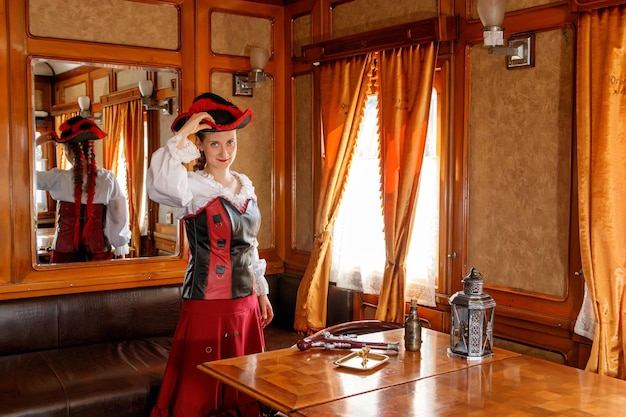 Bella ragazza in costume steampunk in una vecchia carrozza del treno