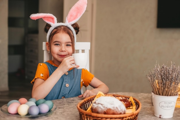 bella ragazza in orecchie da coniglio dipingere le uova di Pasqua