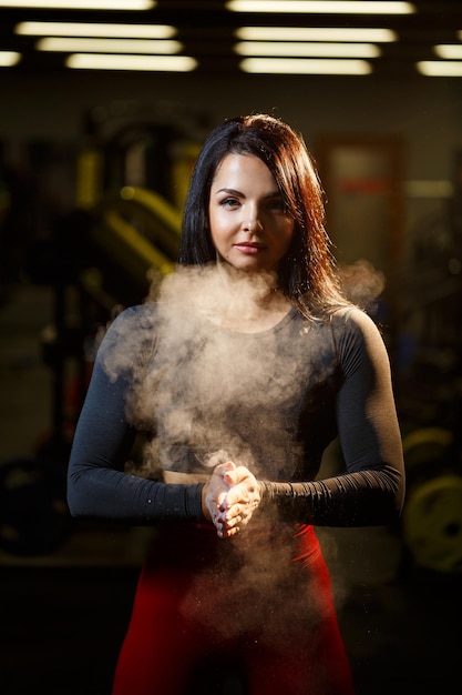 Bella ragazza in palestra con il gesso nelle sue mani