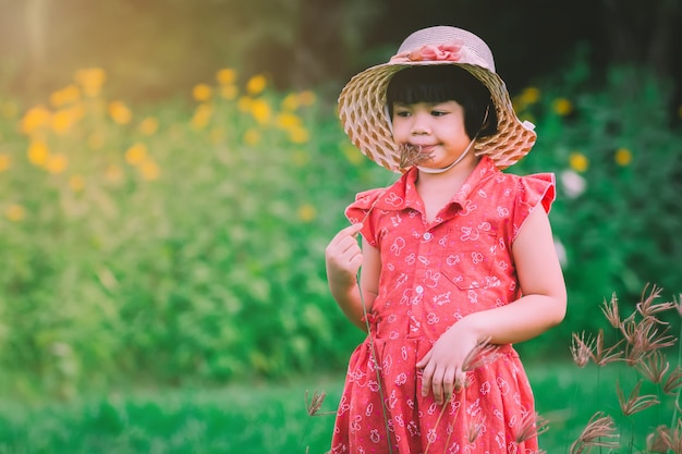 Bella ragazza in piedi in un giardino fiorito e fiori freschi di erba.