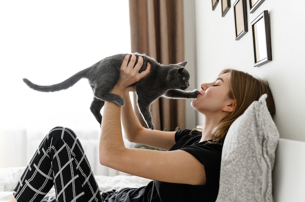 Bella ragazza in pigiama tiene il suo amato animale domestico tra le braccia. Gattino scozzese tra le braccia della ragazza.