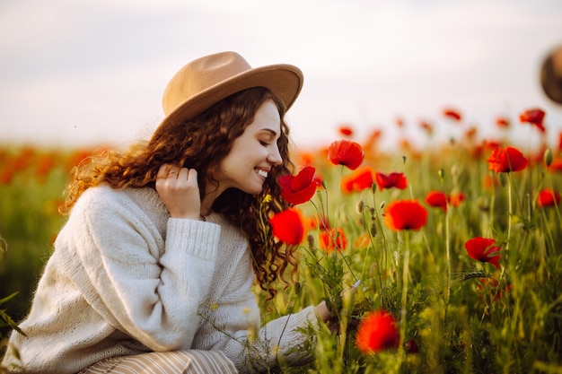 Bella ragazza in posa in un campo di papaveri