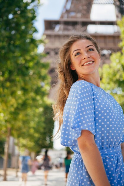 Bella ragazza in posa vicino alla torre eiffel